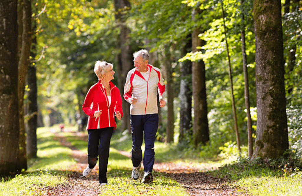 senior couple jogging through wooded area