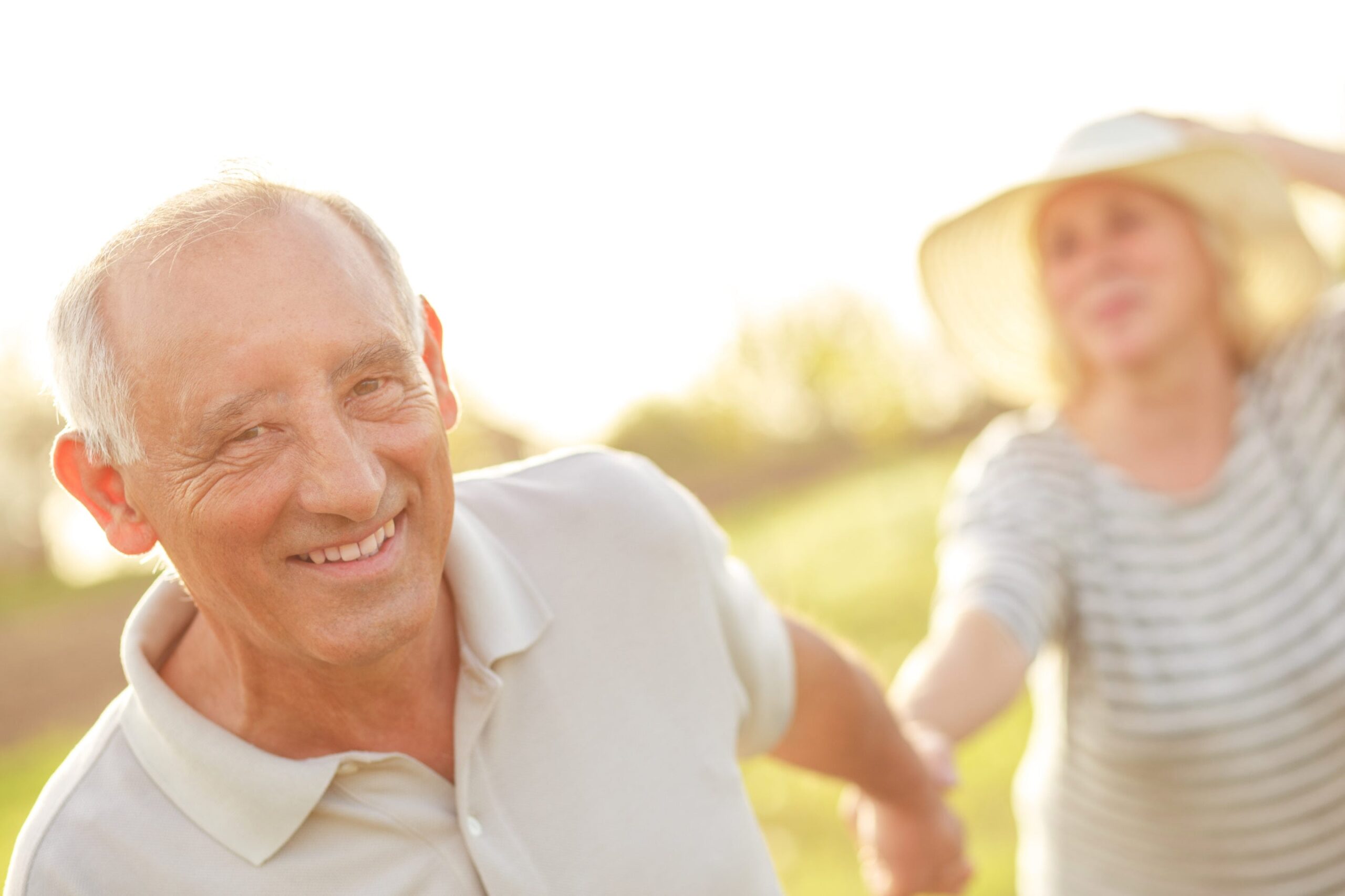 Middle aged couple hand in hand smiling in park